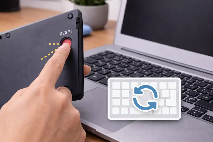 botão de reset em teclado sem fio sendo pressionado para reconectar